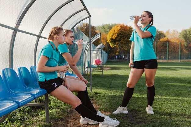 Jóvenes futbolistas bebiendo agua