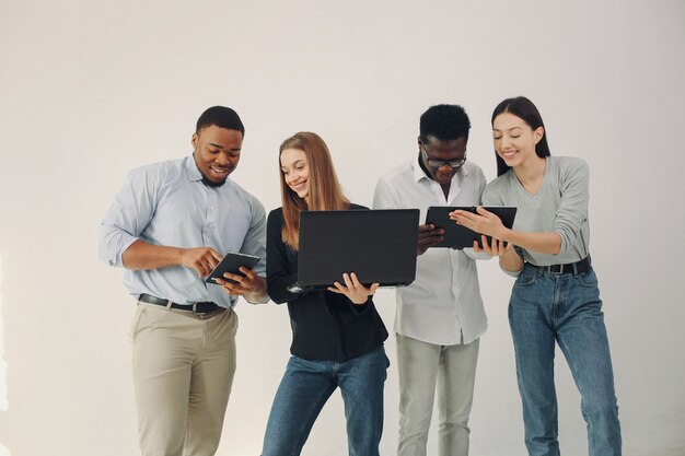 Jóvenes internacionales que trabajan juntos y usan la computadora portátil