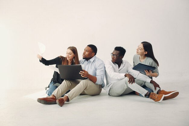 Jóvenes internacionales que trabajan juntos y usan la computadora portátil
