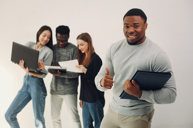 Jóvenes internacionales que trabajan juntos y usan la computadora portátil