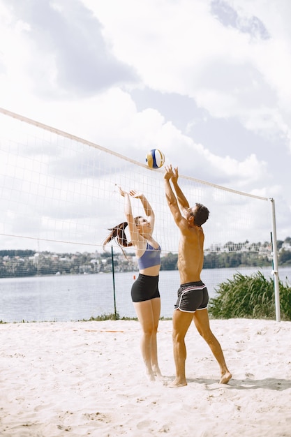 Foto gratuita jóvenes jugando voleibol en la playa