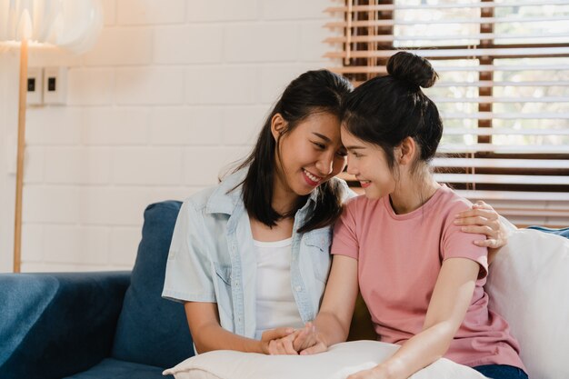 Jóvenes lesbianas lgbtq mujeres asiáticas pareja abrazan y besan en casa