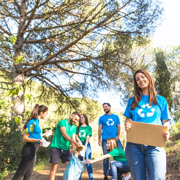 Foto gratuita jóvenes limpiando el bosque de la basura