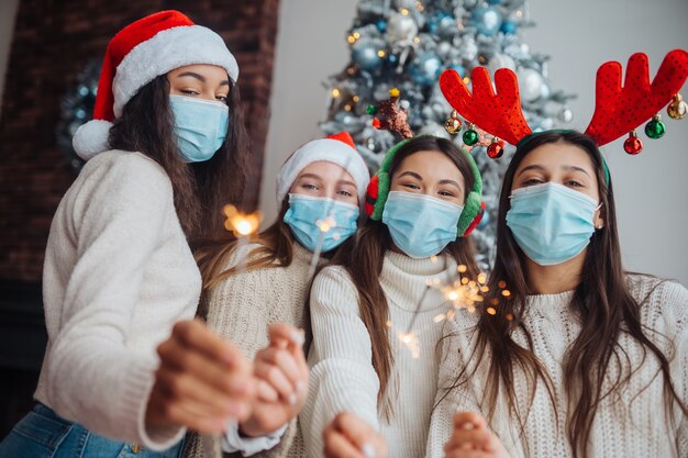 Jóvenes multiétnicos celebrando la víspera de año nuevo con bengalas, amigos multirraciales que se divierten en la celebración de la fiesta