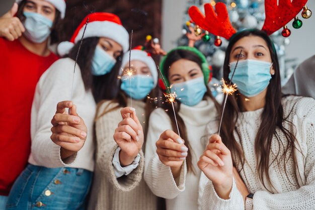 Jóvenes multiétnicos celebrando la víspera de año nuevo con bengalas