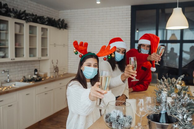 Jóvenes multiétnicos celebrando la víspera de Año Nuevo tintineando vasos brindando, amigos multirraciales divirtiéndose en la celebración de la fiesta, felicitando bebiendo champán