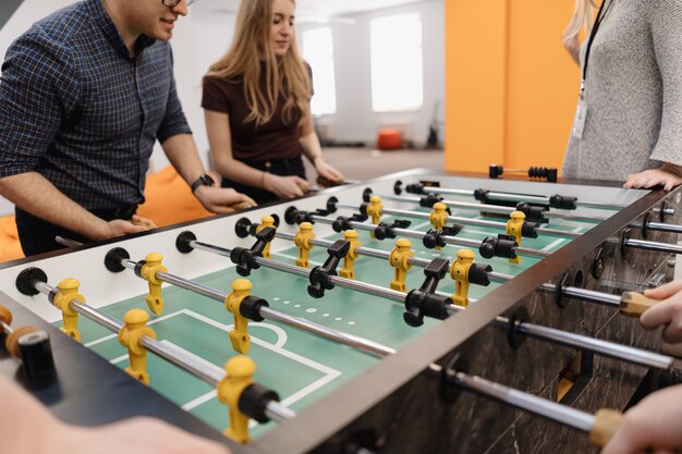 Jóvenes oficinistas jugando futbolín