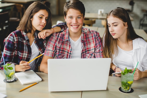 Jóvenes con ordenador portátil en el café