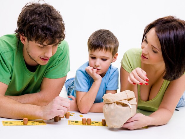 Jóvenes padres felices en el interior jugando con el pequeño hijo