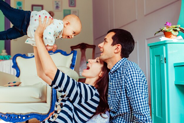 Jóvenes padres jugando con un niño pequeño