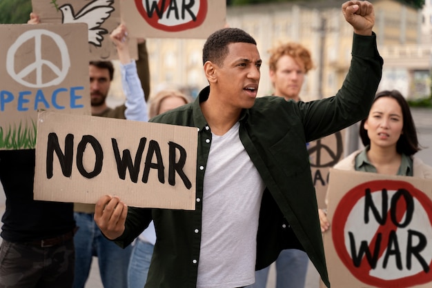 Foto gratuita jóvenes participando en protesta contra la guerra