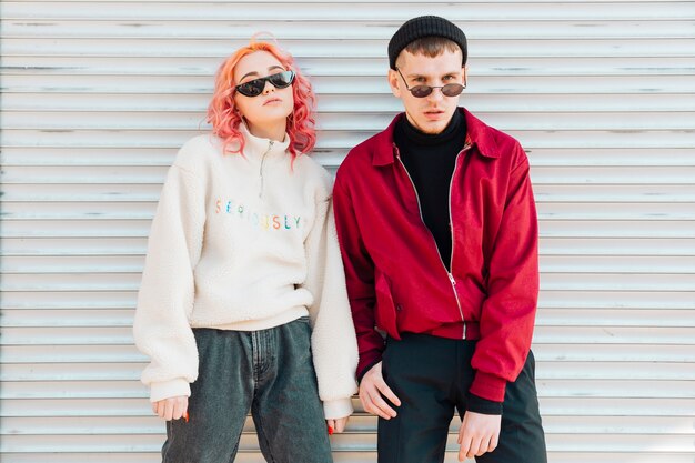 Jóvenes posando con gafas de sol en ropa de primavera cálida