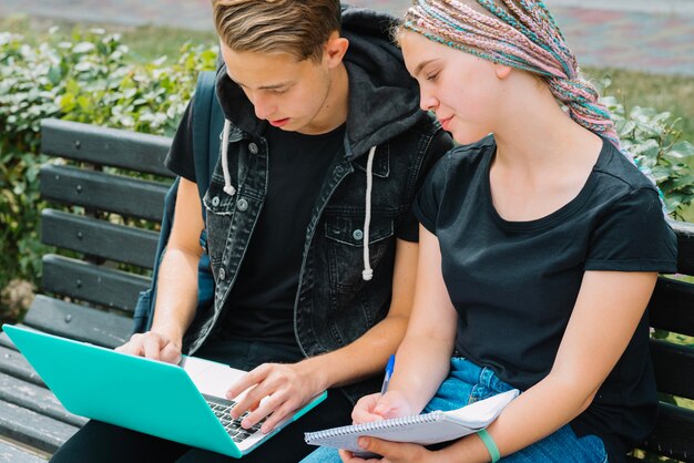 Jóvenes que estudian con la computadora portátil