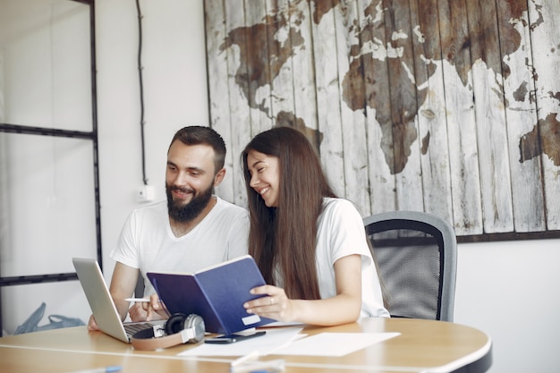 Jóvenes que trabajan juntos y usan la computadora portátil