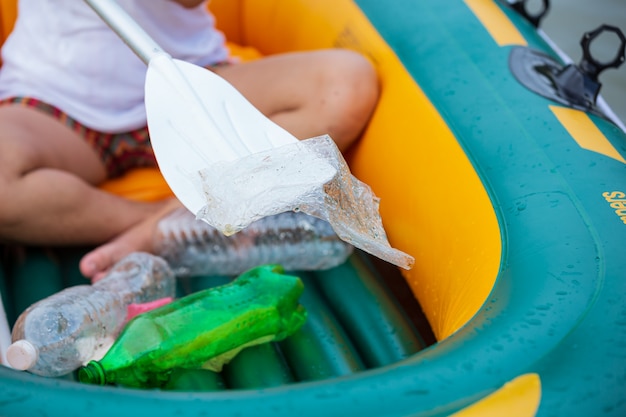 Los jóvenes recolectan basura en el río, concepto del día nacional de la juventud y el día mundial del medio ambiente.