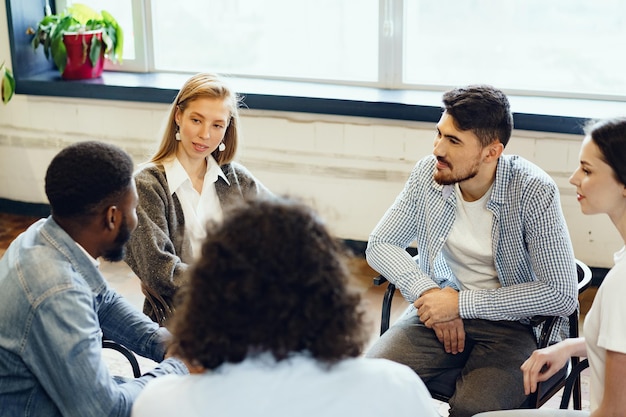 Los jóvenes sentados en círculo y tener una discusión