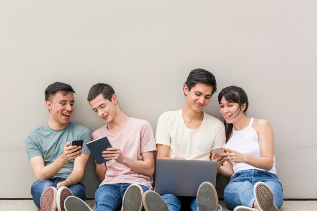 Jóvenes con teléfonos y laptop