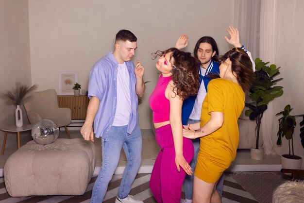 Jóvenes de tiro medio bailando en la fiesta.