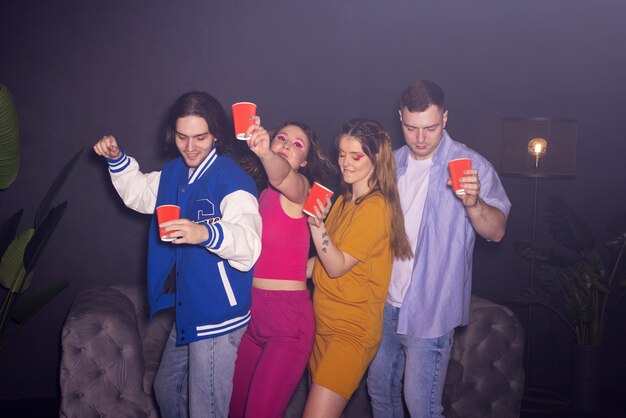 Jóvenes de tiro medio bailando en la fiesta.