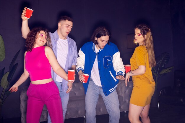 Jóvenes de tiro medio bailando en la fiesta.