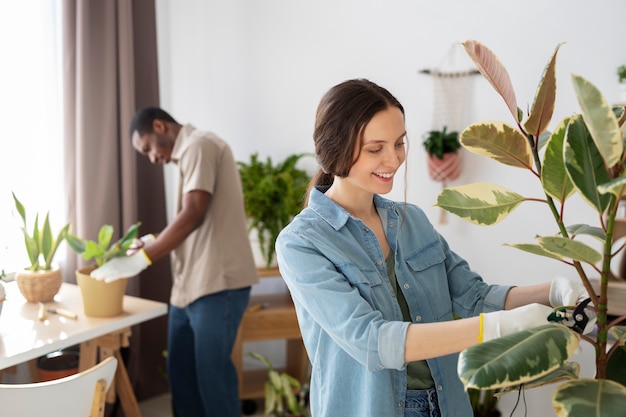 Jóvenes de tiro medio cuidando plantas.