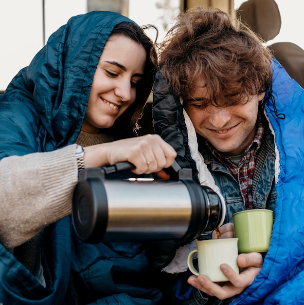 Jóvenes tomando café desde su camioneta