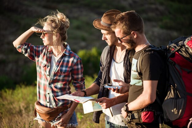 Jóvenes viajeros en busca de ruta en el mapa, caminando en el cañón