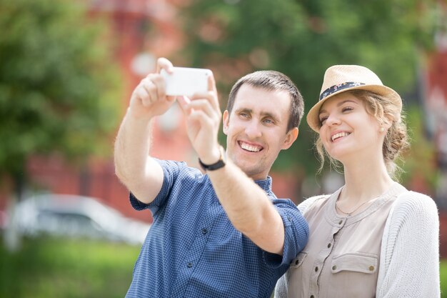 Jóvenes viajeros pareja haciendo selfie durante viaje al extranjero