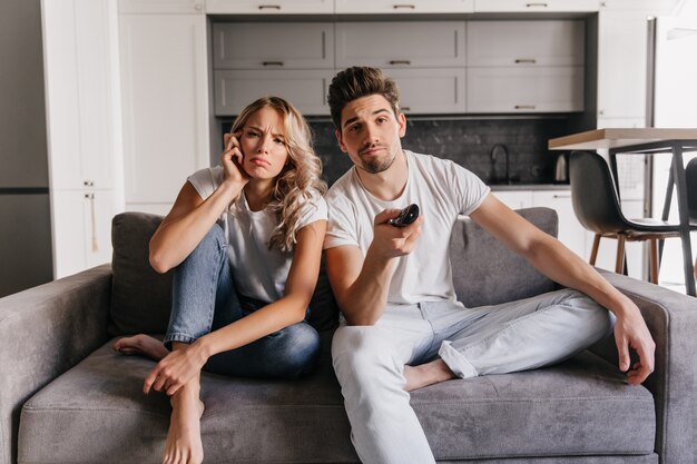 Jóvenes viendo películas. Pareja disfrutando de un programa de televisión.