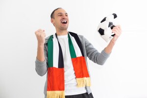 Foto gratuita joyful happy young man in shirt posing background. people sincere emotions lifestyle concept. mock up copy space. holding soccer ball doing winner gesture screaming. high quality photo