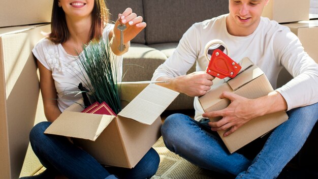 Foto gratuita joyfull pareja empacando cosas en cajas de cartón