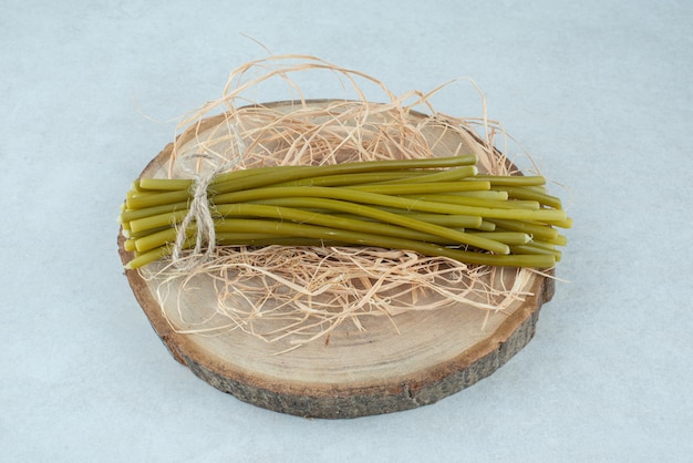 Judías verdes en escabeche sobre pieza de madera.