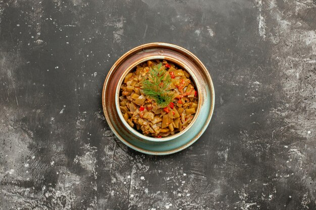 Judías verdes con tomates apetitosas judías verdes con tomates en un recipiente sobre la mesa oscura