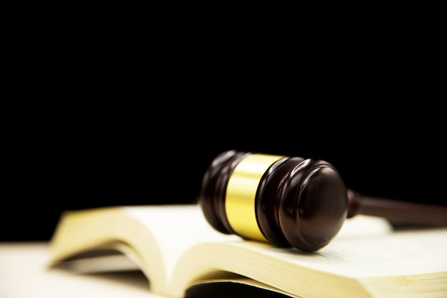 Jueces mazo sobre libro y mesa de madera. Antecedentes del concepto de derecho y justicia.