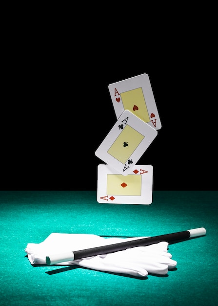 Juego de ases jugando a las cartas sobre el par de guantes blancos con varita mágica