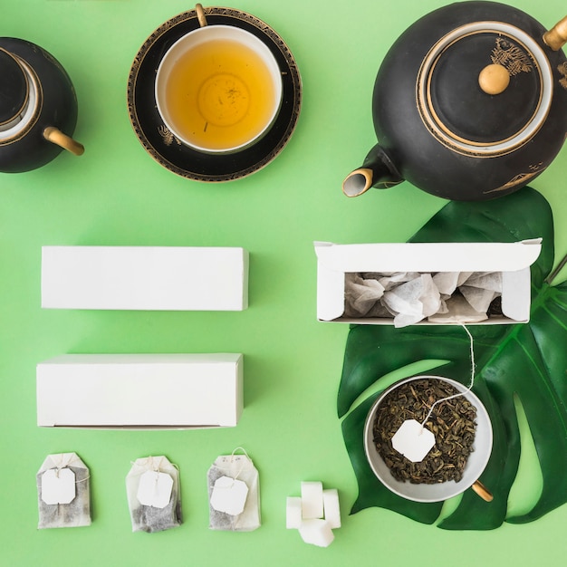 Foto gratuita juego de té asiático clásico con bolsa de té de hierbas en fondo verde