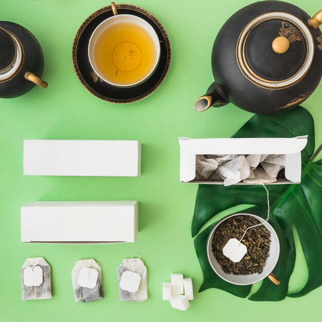 Juego de té asiático clásico con bolsa de té de hierbas en fondo verde