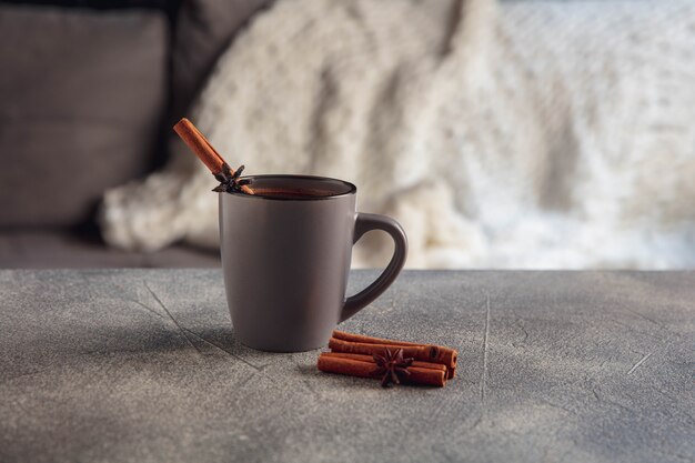 Juego de té blanco y tortas en mesa de madera gris. Bandeja de madera blanca con tazas, tetera y guirnaldas de luces.