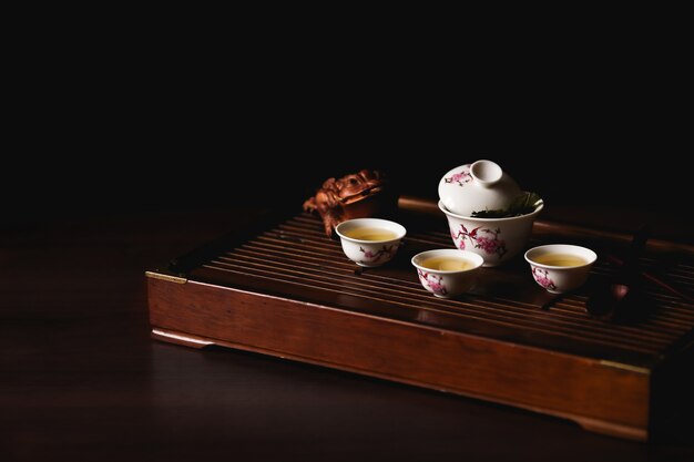 Juego de té chino en el escritorio del té chaban en fondo negro. Ceremonia del té chino