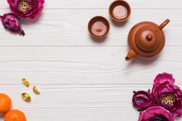 Juego de té y flores en la mesa de madera