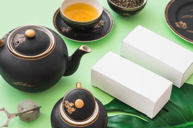 Juego de té de hierbas con dos cajas blancas sobre fondo verde