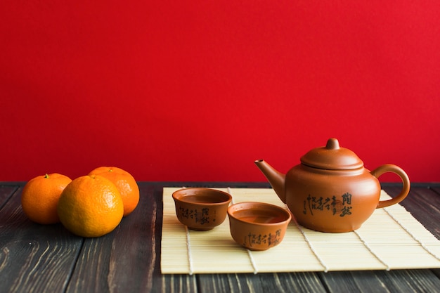 Juego de té y mandarinas en la mesa de madera