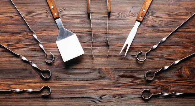 Juego de utensilios de barbacoa en mesa de madera.