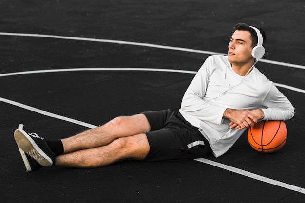 Foto gratuita jugador apoyándose en tiro completo de baloncesto