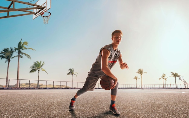 Foto gratuita jugador de baloncesto en acción al atardecer