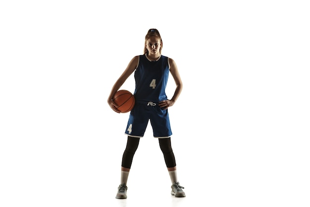 Jugador de baloncesto femenino caucásico joven del equipo que presenta confiado con el balón aislado en el fondo blanco.