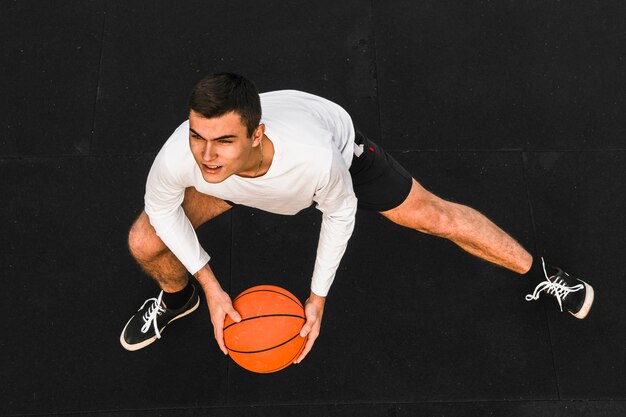 Jugador de baloncesto guapo estirando tiro completo