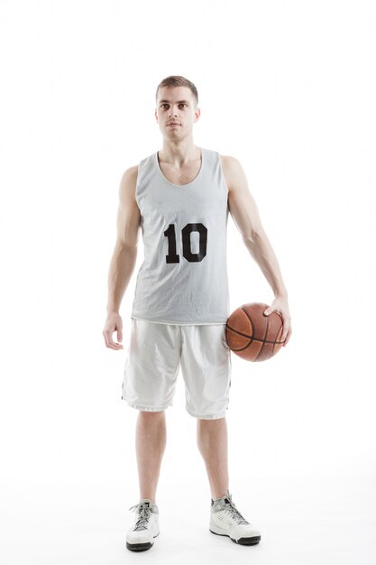 Jugador de baloncesto guapo posando con la pelota