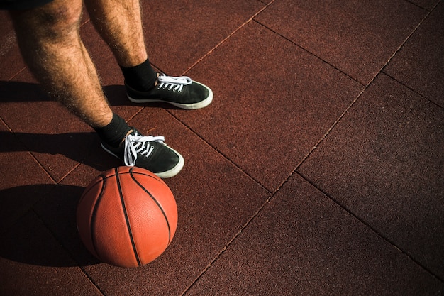 Foto gratuita jugador de baloncesto de pie junto al baloncesto