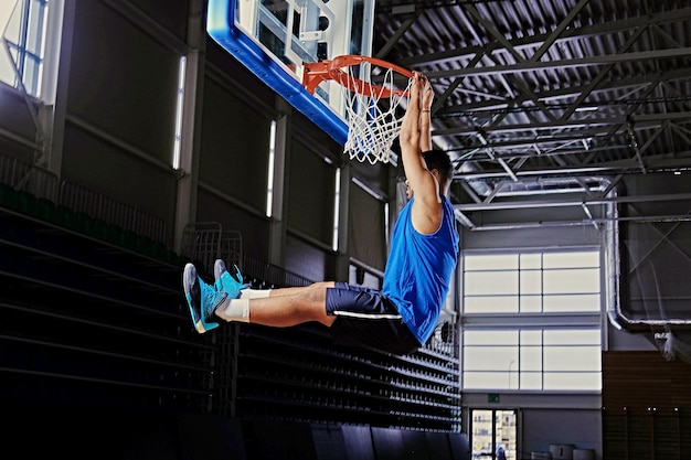 Jugador de baloncesto profesional negro en acción en un campo de baloncesto.